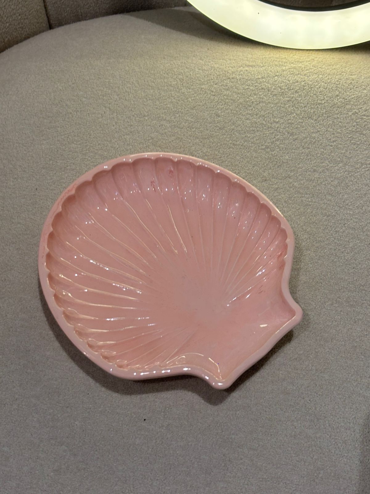 Close up of pink shell-shaped dish on a gray surface